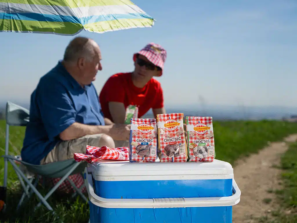 Photo backstage tournage Cochonou - Grand père et petit fils partageantun paquet de Croc'Sec